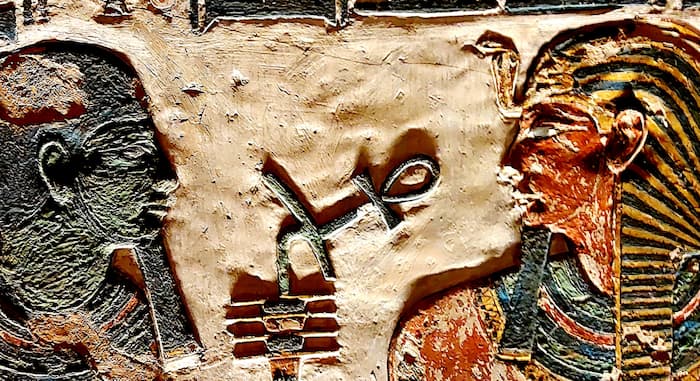 Relieve egipcio: La divinidad transmitiendo el ’nḫ (el aliento vital) a la nariz del faraón